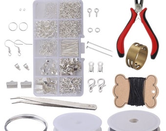 May include: A jewelry making kit with a variety of silver-toned findings, including jump rings, clasps, earring hooks, and beads. The kit also includes tools such as pliers, tweezers, and wire. There are two spools of wire, one black and one white.