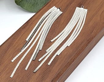 May include: A pair of silver dangle earrings with multiple strands of chain.