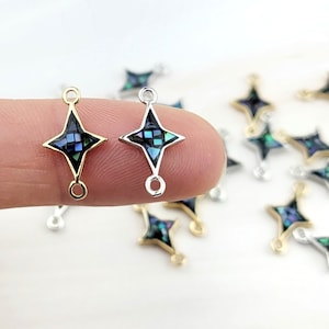 Puede incluir: Un conjunto de 10 conectores en forma de estrella de oro y plata con una incrustación de nácar azul y verde. Los conectores tienen dos bucles en la parte superior e inferior para sujetar joyas.