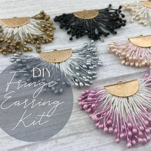 May include: DIY Fringe Earring Kit with six pairs of earrings in various colors, including gold, silver, black, pink, and white. The earrings are made with small, round beads and have a gold metal base.