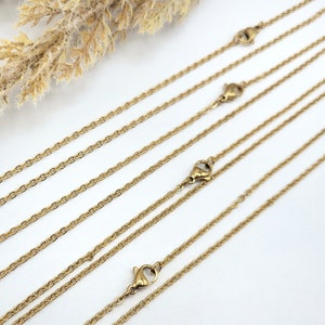 Puede incluir: Cinco collares de cadena de color dorado de diferentes longitudes, todos con cierres de langosta.