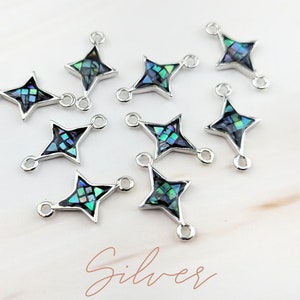 May include: Ten silver star-shaped charms with a blue and green abalone shell inlay. Each charm has two jump rings for attaching to jewelry.