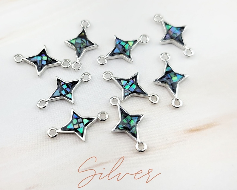 May include: Ten silver star-shaped charms with a blue and green abalone shell inlay. Each charm has two jump rings for attaching to jewelry.