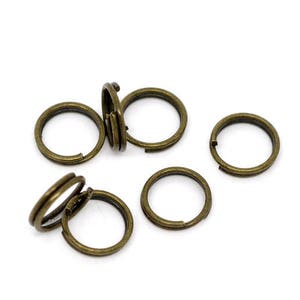 May include: A set of six antique gold jump rings. The rings are all the same size and are made of metal.