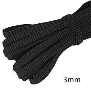 Puede incluir: Un paquete de cordón elástico negro, de aproximadamente 3 mm de ancho, está bien envuelto. El cordón es de color negro liso y parece estar hecho de un material tejido. El texto "3mm" es visible en la esquina inferior derecha.