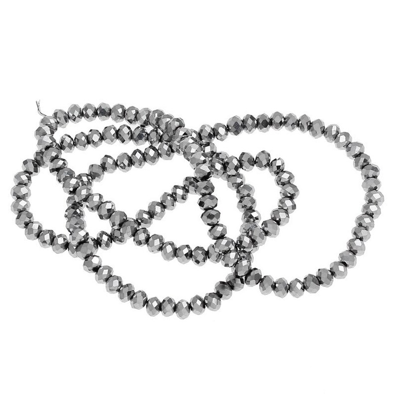 May include: A strand of silver-toned faceted glass beads. The beads are small and round, and they are strung together on a clear thread.
