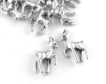 Könnte beinhalten: Silberne Hirsch-Anhänger aus Metall mit gepunktetem Design. Die Anhänger sind klein und detailliert und eignen sich perfekt, um Schmuck oder Bastelarbeiten mit einem Hauch von Verspieltheit zu versehen.