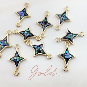 May include: Ten gold star-shaped charms with a black background and iridescent abalone shell inlay. Each charm has two jump rings for attaching to jewelry.