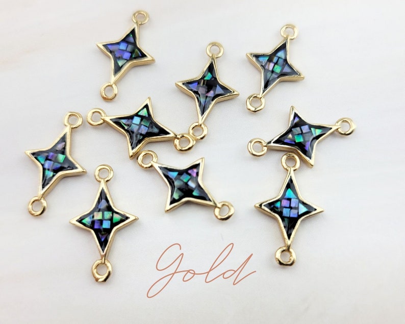 May include: Ten gold star-shaped charms with a black background and iridescent abalone shell inlay. Each charm has two jump rings for attaching to jewelry.