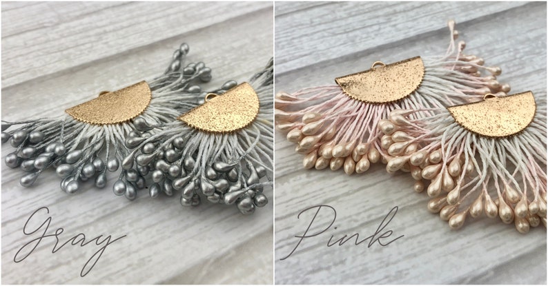May include: Two pairs of earrings with a gold half-circle design and a fringe of small, teardrop-shaped beads. One pair has gray beads and the other has pink beads.
