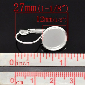 May include: Silver earring with a 1/2 inch (12 mm) round bezel for a cabochon. The earring measures 1-1/8 inches (27 mm) in length.