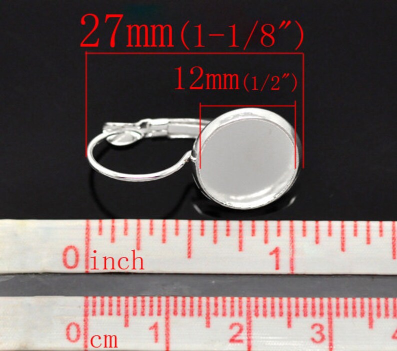 May include: Silver earring with a 1/2 inch (12 mm) round bezel for a cabochon. The earring measures 1-1/8 inches (27 mm) in length.