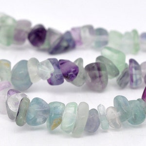 May include: A strand of light green, purple, and white fluorite chip beads. The beads are irregular in shape and have a natural, tumbled finish.