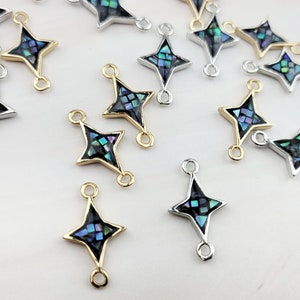 May include: A group of 15 gold and silver star-shaped charms with a blue and green abalone shell inlay. The charms have two jump rings for attaching to jewelry.