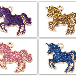 Op de afbeelding: Vier gouden unicorn-bedels met glitteraccenten. De unicorns zijn in paars, goud, roze en blauw.
