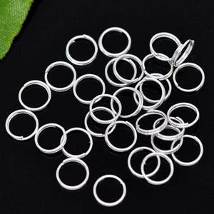 May include: A large quantity of silver jump rings, ideal for jewelry making or crafting projects.