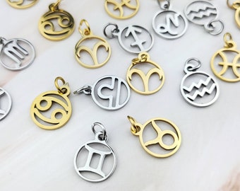 Op de afbeelding: Een verzameling gouden en zilveren dierenriemcharms. Elke charm heeft een ander dierenriemteken, waaronder Ram, Stier, Tweelingen, Kreeft, Leeuw, Maagd, Weegschaal, Schorpioen, Boogschutter, Steenbok, Waterman en Vissen.