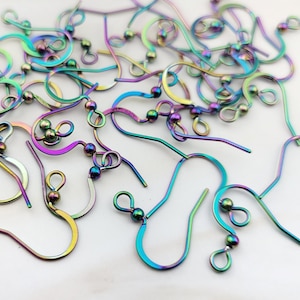 May include: A pile of rainbow-colored earring hooks with small silver beads at the end of each hook.