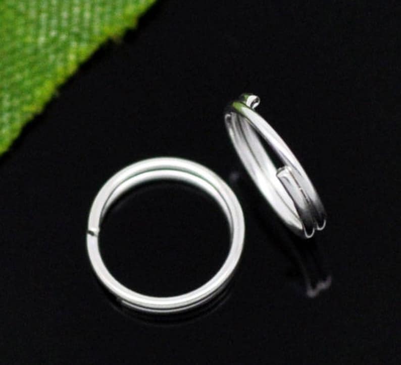 May include: Two silver key rings, one is a single ring and the other is a double ring.