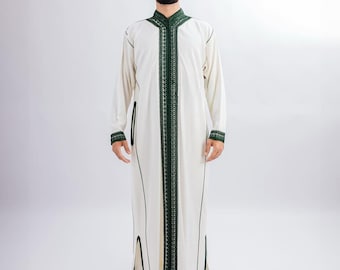 Può includere: Una veste color crema a maniche lunghe con finiture ricamate in verde scuro lungo il colletto, la parte anteriore e i polsini. La veste presenta un colletto alla coreana e spacchi laterali. Il modello indossa scarpe bianche a punta.