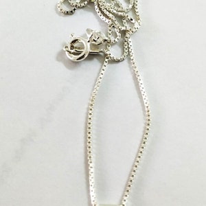 May include: A silver chain necklace with a round opal pendant. The opal is white with green and blue flashes.
