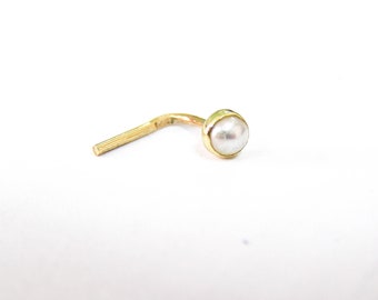 Könnte beinhalten: Ein goldener Nasenring mit einem weißen Perl.