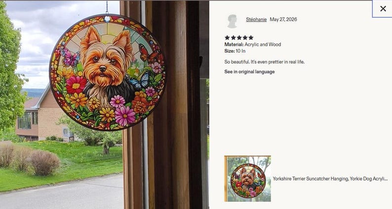 May include: A circular suncatcher featuring a Yorkshire Terrier surrounded by colorful flowers and butterflies. The design is printed on acrylic and wood, measuring 10 inches in diameter. The artwork displays a vibrant stained glass style.