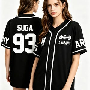 May include: A black baseball jersey with white trim, featuring the text SUGA and the number 93 on the back. The front displays the text ARIRANG with a graphic icon, the BTS logo, and white piping along the button-down placket and sleeve cuffs.