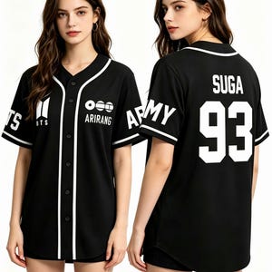 Puede incluir: Camiseta de b&eacute;isbol negra con detalles blancos. La parte delantera muestra el texto "BTS" y "ARIRANG". La parte trasera presenta "SUGA" y el n&uacute;mero "93" en blanco. Las mangas tienen "ARMY" impreso. La camiseta tiene una botonadura.