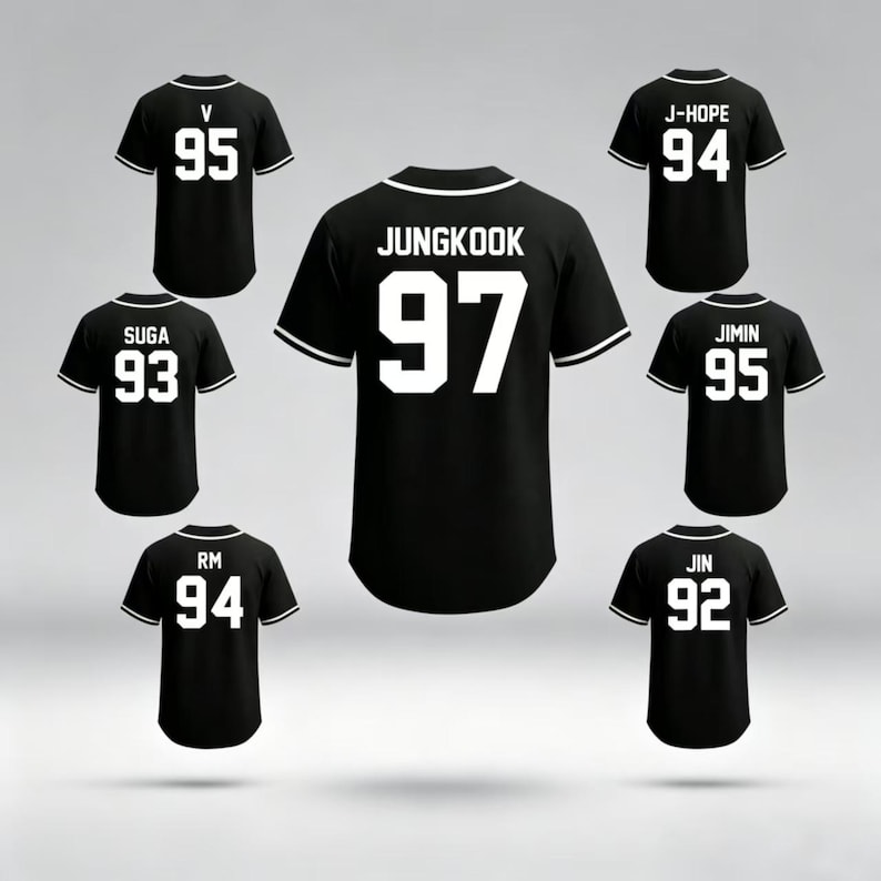 May include: Black baseball jerseys with white accents and player names and numbers. The jerseys feature names like JUNGKOOK, J-HOPE, and JIMIN, with numbers such as 97, 94, and 95. The jerseys are displayed against a light gray background.
