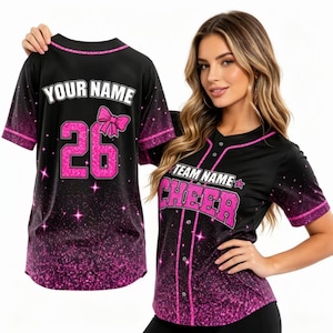 May include: Black baseball jersey with pink accents and the text "TEAM NAME CHEER". The jersey has a pink glitter design at the bottom and on the sleeves. The back of the jersey has the text "YOUR NAME" and the number "26" in pink.