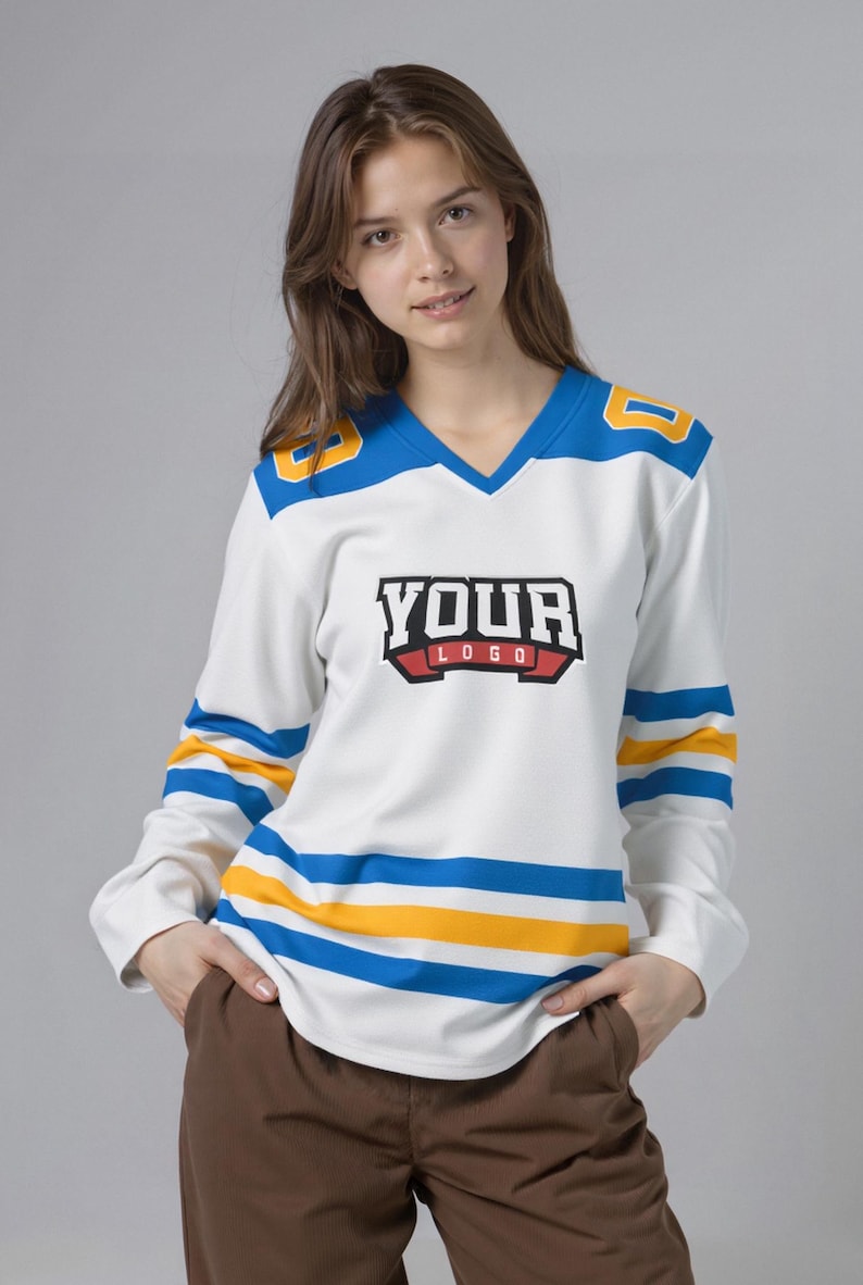 May include: White hockey jersey with blue and yellow detailing. The jersey features a V-neck and long sleeves with blue and yellow stripes. The text "YOUR LOGO" is displayed on the front. The shoulders have the number "8" in yellow.