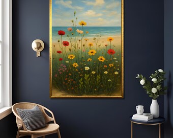 Puede incluir: Pintura enmarcada de un campo de flores silvestres con flores rojas, amarillas, rosas y blancas, frente a una playa y un océano bajo un cielo azul. El marco es dorado.