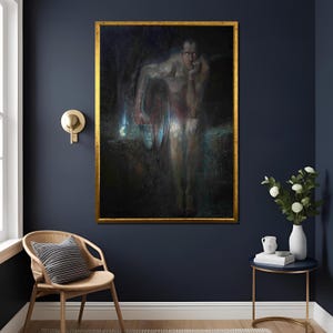 May include: A framed painting with a gold border depicts a nude figure holding a light source. The artwork has a dark, moody color palette with shades of blue, black, and red. The painting is displayed on a dark blue wall.