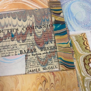 May include: A close-up of a vintage marbled paper with text that reads "OUTH'S COMPANIO" and "BAZAR DRESSI For Spring and Summ" with the name "JAMES MCCALL" at the bottom. The text is printed on a light blue background with a marbled pattern.