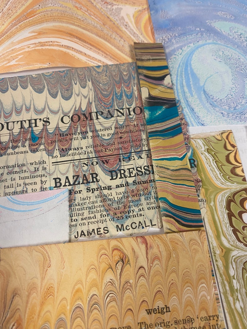 May include: A close-up of a vintage marbled paper with text that reads "OUTH'S COMPANIO" and "BAZAR DRESSI For Spring and Summ" with the name "JAMES MCCALL" at the bottom. The text is printed on a light blue background with a marbled pattern.