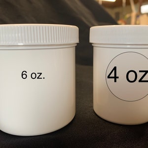Op de afbeelding: Twee witte plastic containers met deksels. De container aan de linkerkant is geëtiketteerd met "6 oz." en de container aan de rechterkant is geëtiketteerd met "4 oz."