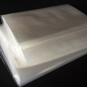 May include: A stack of clear plastic bags, folded and ready to use. The bags are translucent and appear to be made of a thin, flexible material.