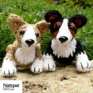 May include: Two crocheted stuffed dog toys, one brown and white and one black and white, sitting on a wooden surface. The toys are both wearing a white crocheted collar.