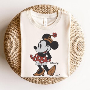 a mickey mouse shirt sitting on top of a wicker basket