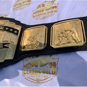 May include: A gold and black wrestling championship belt. The belt features gold plates with the words "Continental Wrestling" and images of wrestlers. The belt is made of black leather and has gold accents. The image also shows the Classic Gold Sports logo.