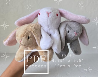 Könnte beinhalten: Drei Plüsch-Hasenspielzeuge in Beige, Weiß und Grau, jeweils mit langen Ohren und gestickten Gesichtsdetails. Die Größe beträgt 12cm x 9cm. Das Bild enthält den Text "PDF pattern".