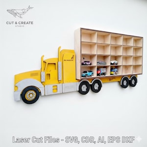 Könnte beinhalten: Ein gelb-graues Holzregal in Form eines Spielzeug-LKWs mit mehreren Fächern für Spielzeugautos. Der LKW hat ein "MACK"-Logo und der Text "CUT & CREATE STUDIO" ist sichtbar. Das Regal ist für die Wandmontage konzipiert.