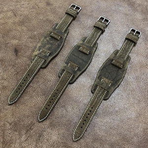 Könnte beinhalten: Drei braune Lederarmbänder für Uhren mit weißen Nähten und einer strukturierten Oberfläche. Die Armbänder haben Metallschließen.