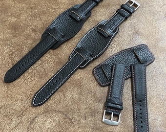 May include: Three black leather watch straps with white stitching. Two straps are wider and have a buckle on each end. The third strap is narrower and has a buckle on one end.