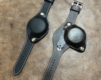 May include: Two leather watch straps with a pocket for a watch face. The strap on the left is black and the strap on the right is brown.