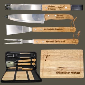 Könnte beinhalten: Ein Set aus Edelstahl-Grillwerkzeugen mit Holzgriffen, darunter eine Zange, ein Messer, ein Spatel und eine Gabel. Das Set enthält ein Holzschneidebrett und eine Tragetasche. Der Text "Michaels Grillzange", "Michaels Grillmesser", "Michaels Grillwender" und "Michaels Grillgabel" sind sichtbar.