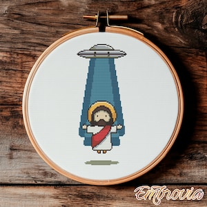May include: A cross-stitch pattern featuring a cartoon depiction of Jesus being beamed up by a UFO. The UFO is gray with a blue beam of light. Jesus is wearing a white robe and a red sash.