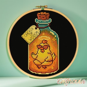 May include: Cross-stitch art in a wooden hoop. The design features a yellow chicken wearing sunglasses inside a potion bottle. The bottle has a cork stopper and a tag that reads "Chicken of Wisdom". The background is black.