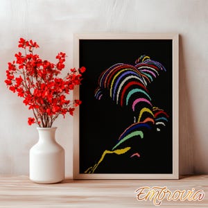 May include: A framed artwork with a black background features a colorful, abstract design of curved lines. The artwork is in a light-colored wooden frame. A white vase with red flowers is on a wooden surface.